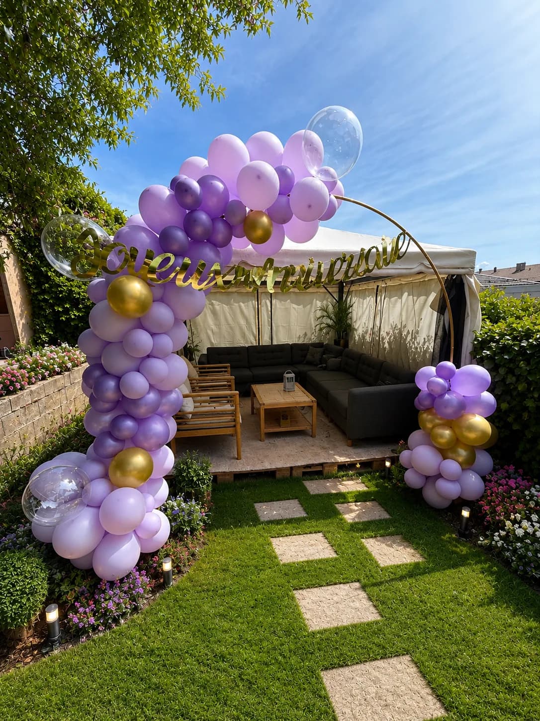 Arche ronde de ballons violet et or Joyeux anniversaire dans un jardin