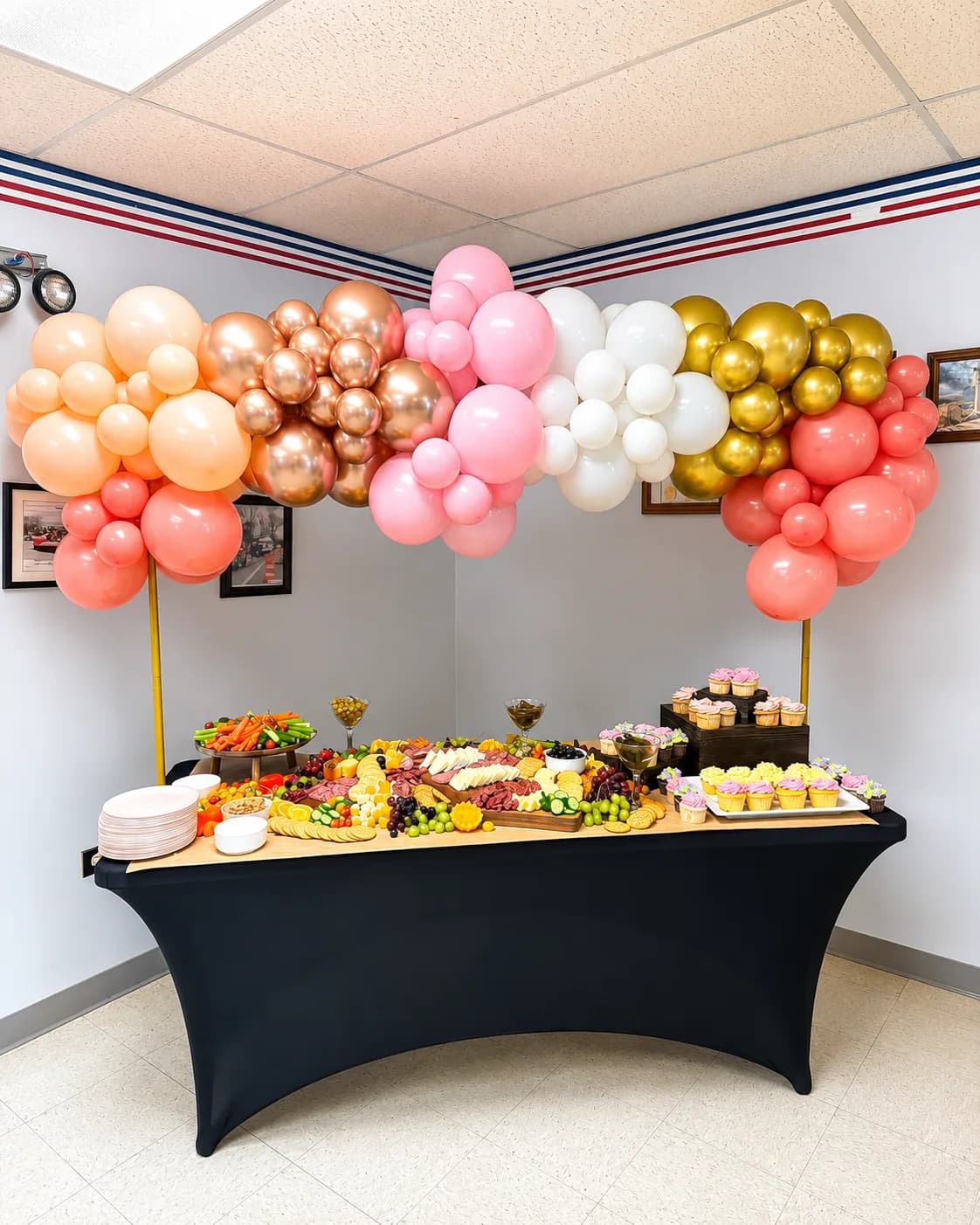 Guirlande de ballons multicolore au-dessus d'une grazing table