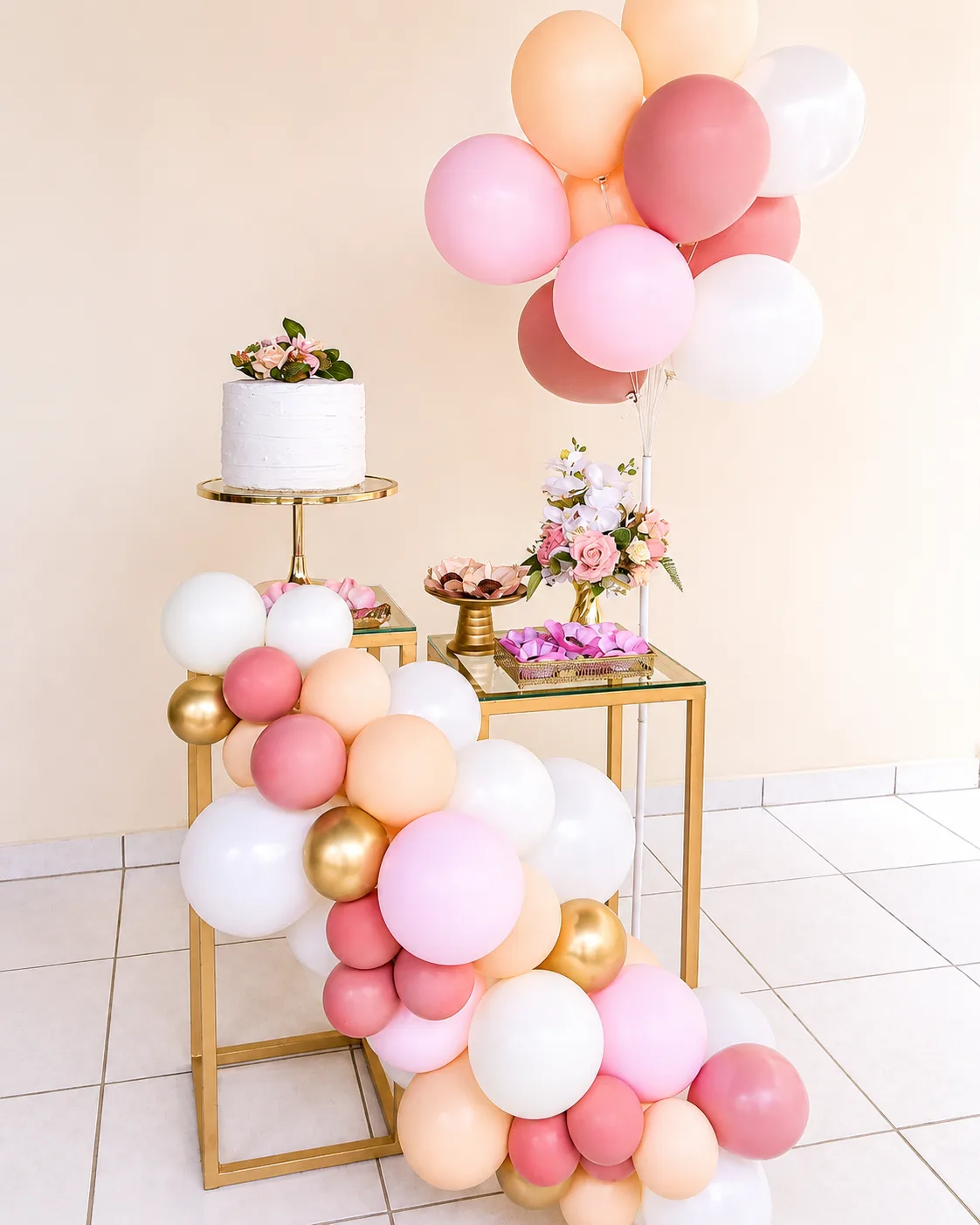 Sweet table dorée avec gâteau et guirlande de ballons rose et pêche