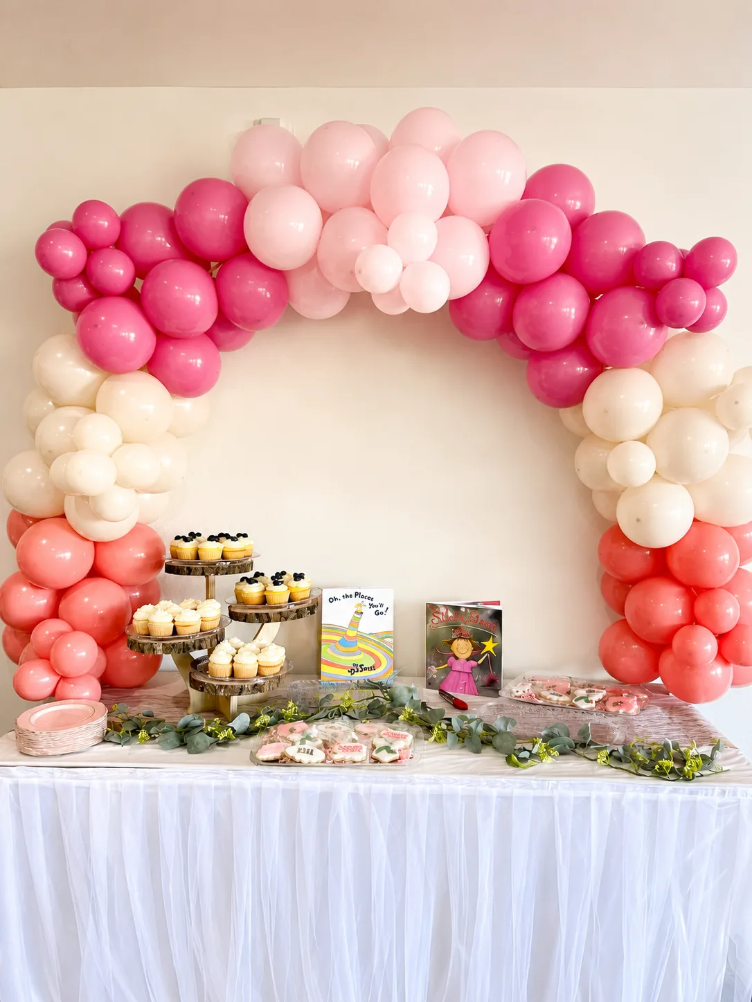 Arche de ballons dégradée fuchsia, corail et crème avec sweet table